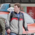 Young man having a seizure while crossing the street.